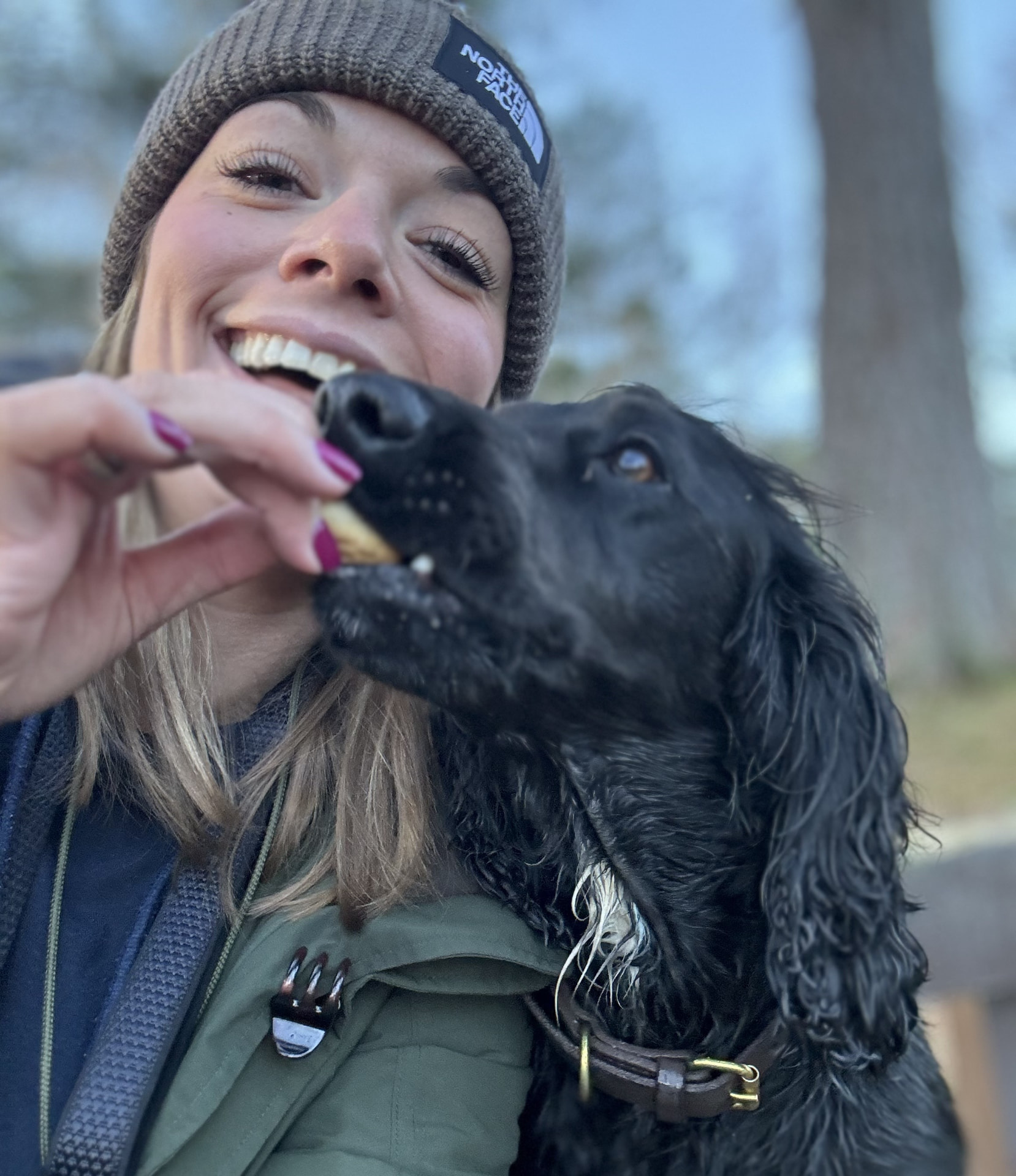 A friendly dog walker smiling with a happy black dog